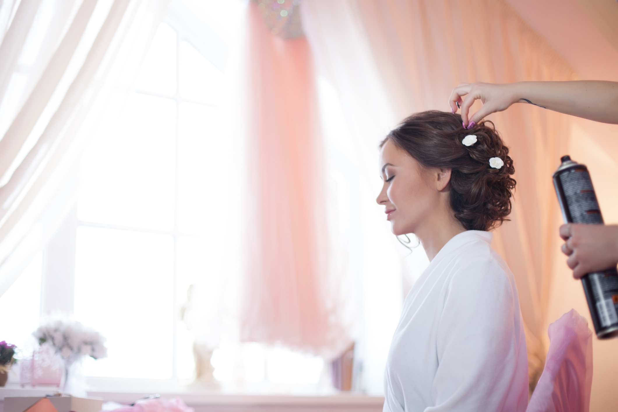 Stylist pinning up a bride's hairstyle