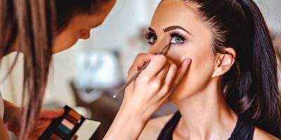 Makeup artist applying eyeshadow on a beautiful girl