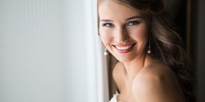 Beautiful smiling Bride wedding Portrait with wedding hairstyle, Wedding dress. Wedding decoration. soft selective focus. gorgeous young woman in hotel room
